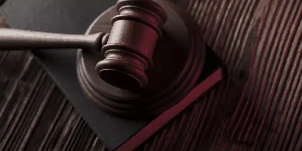 Close-up of a judge’s gavel resting on a closed legal book atop a wooden surface, symbolizing legal authority or lease enforcement.